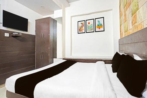 a bedroom with a large bed and a television at Super Collection O Prabhat Nagar Bareilly in Bareilly