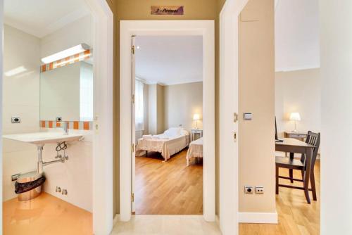 GarínoainにあるVer Venir, acogedoras habitaciones con piscinaの洗面台付きのバスルームとベッド付きの部屋