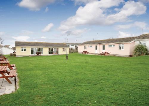 a large yard with tables and a building at Anglesey Bungalows in Trearddur