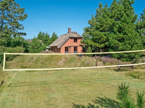 ein Netz auf einem Feld mit einem Haus im Hintergrund in der Unterkunft Holiday Home Siegried - 2-2km from the sea by Interhome in Vesterhede