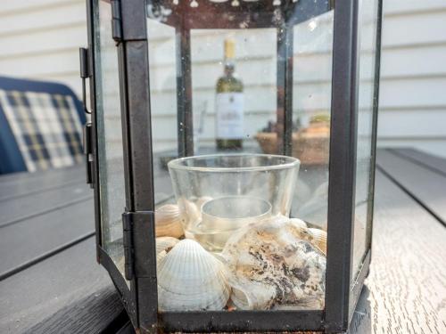a glass container filled with shells on a table at Apartment Helvig - 2-3km from the sea by Interhome in Sønderby