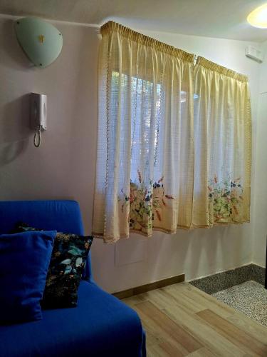a living room with a blue couch and a window at Peter's apartment - intero appartamento con balcone in Castel SantʼElia