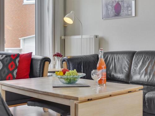 a table with a bottle of wine and a bowl of fruit at Apartment Mariam - 2-3km from the sea by Interhome in Sønderby