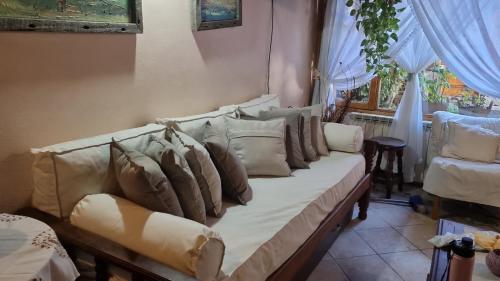 a couch with pillows on it in a living room at Cabañas frente al lago vista al jardin in San Martín de los Andes