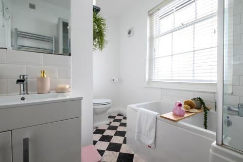 une salle de bain avec une baignoire, un lavabo et des toilettes dans l'établissement Beautiful Mews Cottage near Brighton Seafront in Rottingdean Village, à Rottingdean