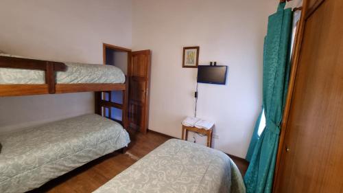 a small room with two bunk beds and a television at Cabañas frente al lago vista al jardin in San Martín de los Andes