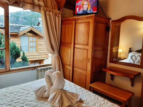 a room with a bed and a tv on at Cabañas frente al lago vista al jardin in San Martín de los Andes