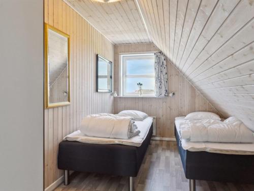 two beds in a small room with a window at Holiday Home Andor - 500m from the sea by Interhome in Lakolk