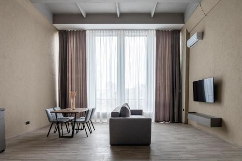 a living room with a table and a couch and a television at REST INN apart hotel in Cherkasy