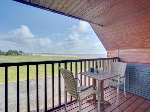 Un patio con una mesa y sillas en un balcón. en Holiday Home Perttu - 3-5km from the sea by Interhome, en Kongsmark