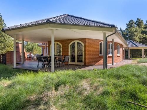 a pavilion with a table and chairs on a deck at Holiday Home Agusta - 1-1km from the sea by Interhome in Mølby