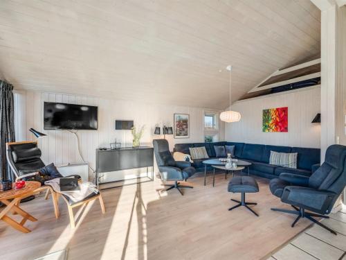 a living room with blue furniture and a tv at Holiday Home Hermandine - 700m from the sea by Interhome in Lakolk