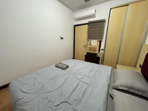 a bedroom with a bed with a pillow on it at Borneo Home Imperial Suites Kuching Boulevard Mall in Kuching