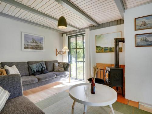 a living room with a couch and a table at Holiday Home Benedikta - 2-4km from the sea by Interhome in Vesterhede