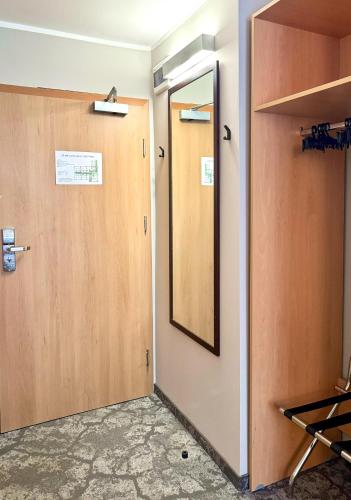 a bathroom with a door and a mirror at Malinowski Leśny in Gliwice