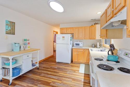 cocina con nevera blanca y suelo de madera en 5049 - Carolyn's Getaway, en Kill Devil Hills