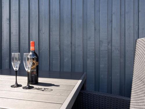 a bottle of wine and a glass on a table at Holiday Home Freek - 400m from the sea by Interhome in Lakolk