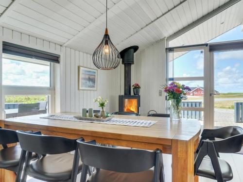 a dining room with a table and chairs and a fireplace at Holiday Home Freek - 400m from the sea by Interhome in Lakolk