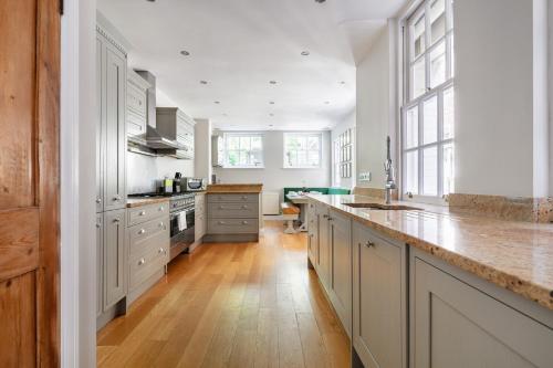 a large kitchen with white cabinets and a wooden floor at Castle View in Windsor