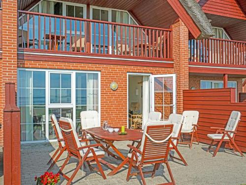 a patio with a table and chairs and a balcony at Holiday Home Henrietta - 3-5km from the sea by Interhome in Kongsmark