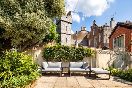 two benches sitting on a patio in front of a fence at Castle View in Windsor