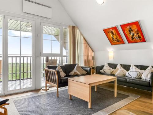 a living room with a couch and a table at Holiday Home Henrietta - 3-5km from the sea by Interhome in Kongsmark