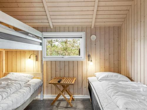 two beds in a room with a window at Holiday Home Svenny - 800m from the sea by Interhome in Lakolk