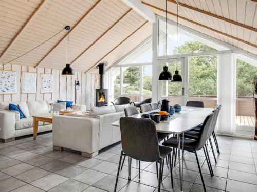a dining room and living room with a table and chairs at Holiday Home Svenny - 800m from the sea by Interhome in Lakolk