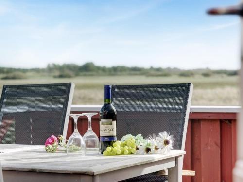 a table with two bottles of wine and flowers on it at Holiday Home Mortensen - 350m from the sea by Interhome in Lakolk