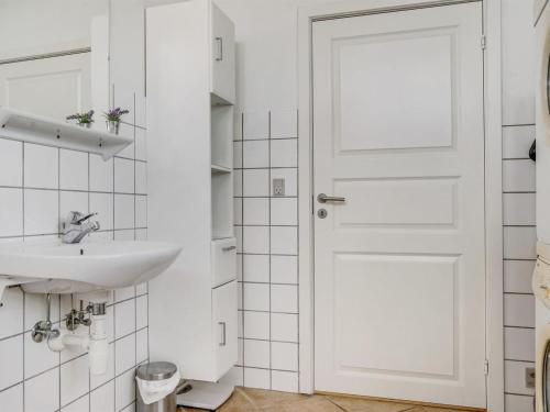 a bathroom with a white door and a sink at Holiday Home Mortensen - 350m from the sea by Interhome in Lakolk