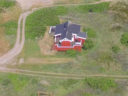 a house in the middle of a field with a road at Holiday Home Mortensen - 350m from the sea by Interhome in Lakolk