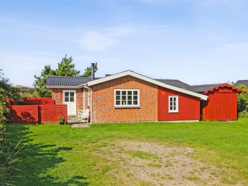 a red brick house with a red fence at Holiday Home Hendrine - 500m from the sea by Interhome in Lakolk