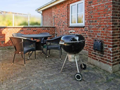 a bbq grill sitting next to a brick wall at Holiday Home Hendrine - 500m from the sea by Interhome in Lakolk