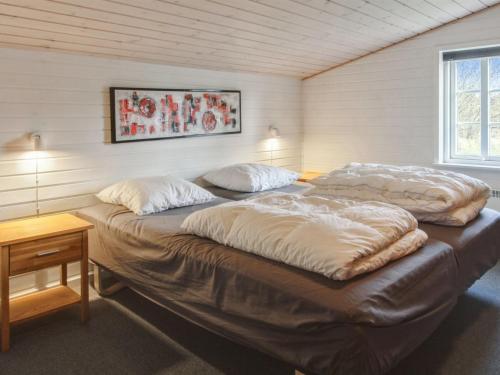 a large bed in a room with two pillows on it at Holiday Home Hendrine - 500m from the sea by Interhome in Lakolk