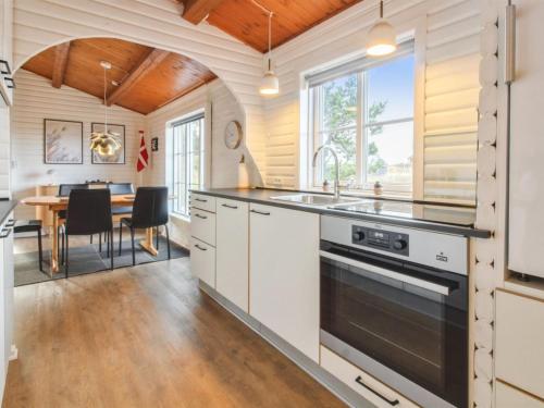 a kitchen with white cabinets and a wooden ceiling at Holiday Home Hendrine - 500m from the sea by Interhome in Lakolk