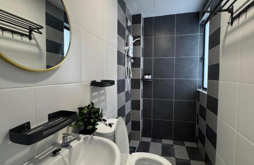 une salle de bain avec un lavabo, des toilettes et un miroir dans l'établissement Manhattan Ipoh Family Suites By Inn Lux, à Ipoh
