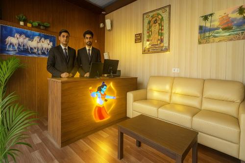 two men are standing at a counter in a room at Ramayana Grand Hotel Ayodhya - A Step Away from Shri Ram Mandir in Ayodhya