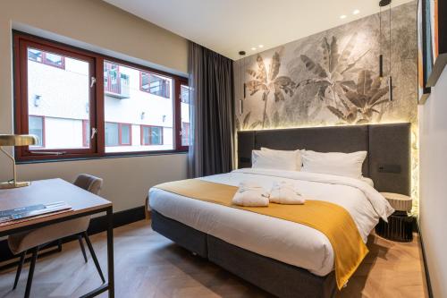 a bedroom with a large bed with two towels on it at MyHotel Meppel in Meppel