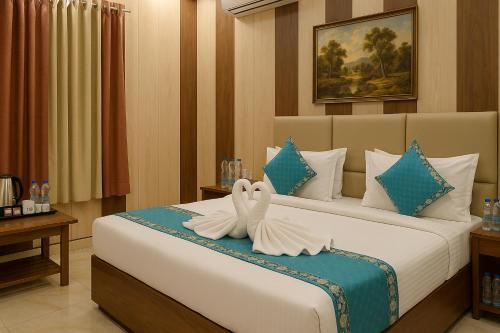 a bedroom with a bed with two towels on it at Ramayana Grand Hotel Ayodhya - A Step Away from Shri Ram Mandir in Ayodhya