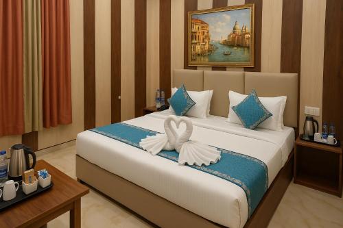 a hotel room with a bed with a bow on it at Ramayana Grand Hotel Ayodhya - A Step Away from Shri Ram Mandir in Ayodhya