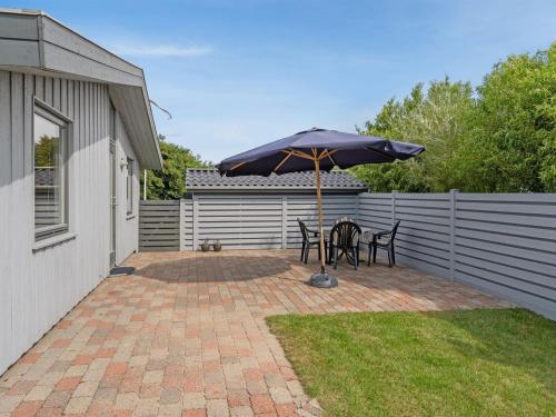 a patio with two chairs and an umbrella at Holiday Home Elise - 800m from the sea by Interhome in Lakolk