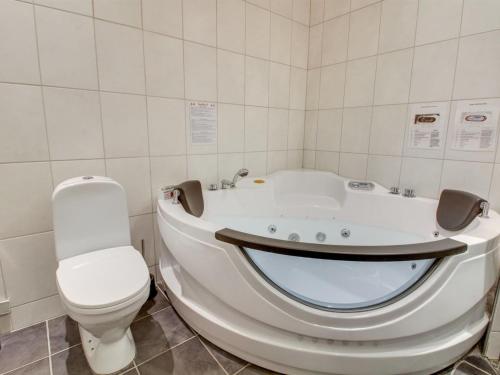 a white bathroom with a tub and a toilet at Holiday Home Eda - 3-5km from the sea by Interhome in Kongsmark