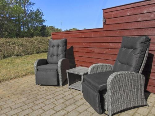 two chairs and a table and two chairs and a fence at Holiday Home Eda - 3-5km from the sea by Interhome in Kongsmark