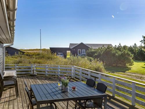 a patio with a table and chairs on a deck at Holiday Home Aika - 500m from the sea by Interhome in Lakolk