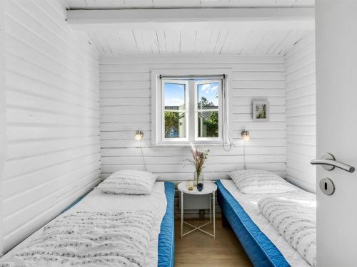 two beds in a room with a window at Holiday Home Aika - 500m from the sea by Interhome in Lakolk