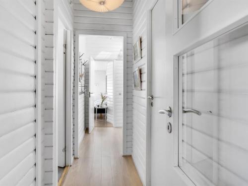 a hallway with white walls and a door at Holiday Home Aika - 500m from the sea by Interhome in Lakolk