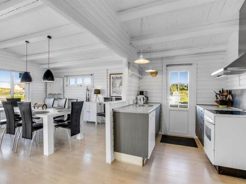 a kitchen and dining room with a table and chairs at Holiday Home Aika - 500m from the sea by Interhome in Lakolk