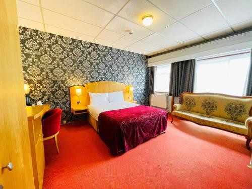 a hotel room with a bed and a couch at Westone Manor Hotel in Northampton