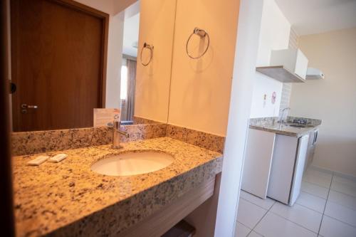 a bathroom with a granite counter top with a sink at Riviera Park in Caldas Novas