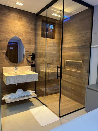 a bathroom with a shower and a sink and a mirror at Status Motel Ourinhos in Ourinhos